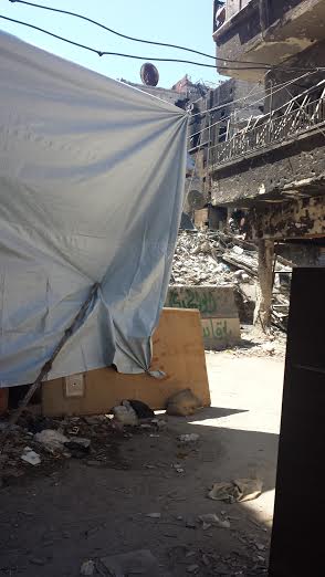 A sheet is draped in a Yarmouk passage to protect against snipers gaining visual targets.